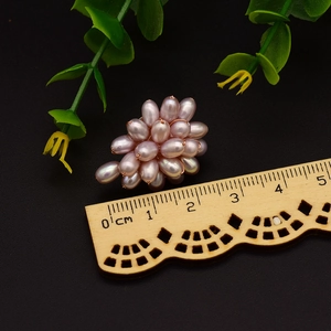 Elegant purple cluster pearl earrings with rice-shaped beads on a textured wood surface