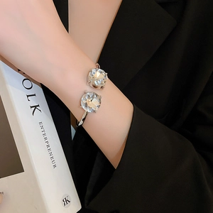 Detailed view of silver open cuff bracelet with large faceted crystals on a model