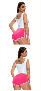 Detail showing the white slim fit tank top and pink high-waist stretch yoga shorts