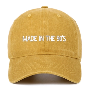 Close-up of yellow washed canvas baseball cap with white MADE IN THE 90'S embroidery