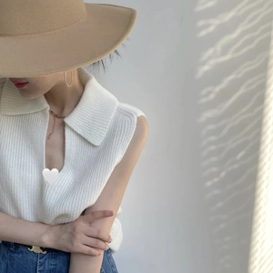 Polo sans manches en maille blanche avec col en V et texture côtelée détaillée