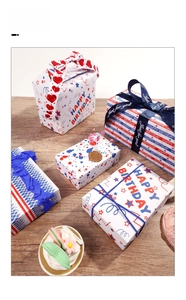 Detail of Happy Birthday gift boxes with navy blue ribbons on a wooden surface