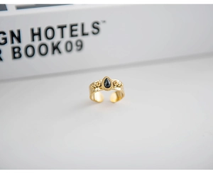 Macro shot of 18K gold plated ring featuring a black pear-cut stone and bead accents