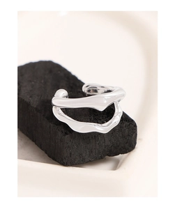 Macro shot of silver liquid-style double-layered ear clip on a black textured base