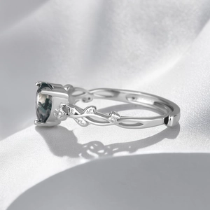 Macro shot of silver moss agate ring featuring vine leaf band and sparkling zircon accents