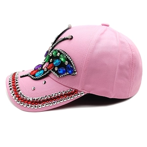 Detailed view of pink baseball cap featuring large colorful rhinestone butterfly pattern