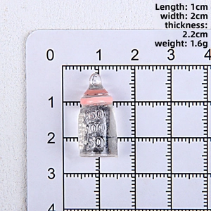 Detailed scale view of miniature resin baby bottle charms with pink rings for DIY crafts