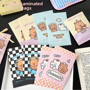Détail à plat de pochettes à motif d'ours de dessin animé en jaune, bleu et rose
