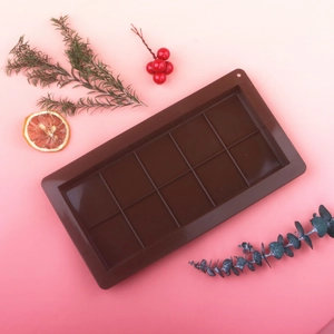 Detailed macro of 10-cavity brown silicone chocolate mold with orange slice decor