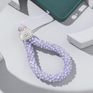 Detail of beaded lavender phone strap with crystal accents on a green silicone case
