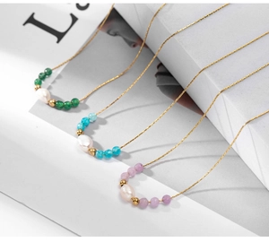 Close-up of 18K gold plated necklaces featuring baroque pearls and colorful faceted beads