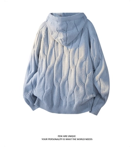 Rear view of light blue cable knit hooded sweater showing textured weave and ribbed hem