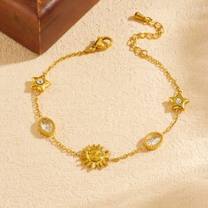 Gold-plated stainless steel bracelet featuring sun, star motifs and sparkling clear crystals