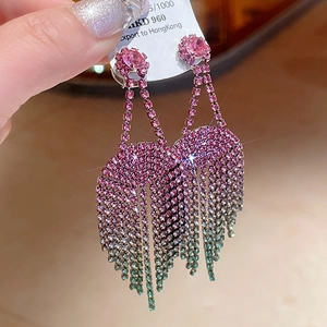 Gros plan de boucles d'oreilles de luxe à pampilles en strass dégradé rose et vert