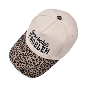 Close-up of Somebody's Problem embroidery on leopard print trucker hat with canvas fabric