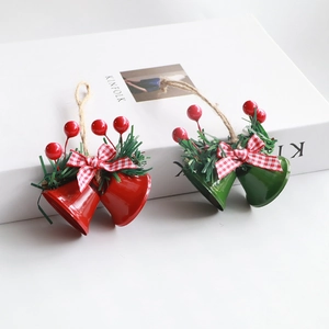 Detail of red and green metal Christmas bells with pine needles and plaid bows