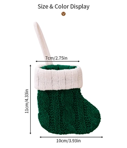 Size display of a mini green knitted Christmas stocking for tree decorations