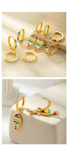 Detail view of gold hoop earrings with enamel fish charms and evil eye design