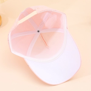 Detail of pink baseball cap interior showing adjustable strap and breathable top button
