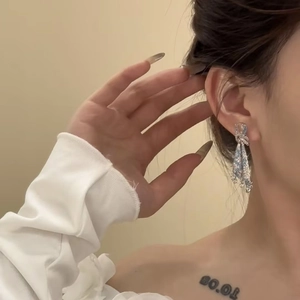 Detailansicht eleganter funkelnder Ohrhänger mit hellblauen Strasssteinen am Model.