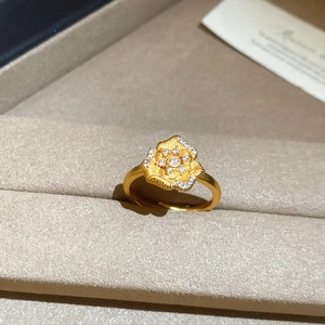 Macro shot of 24K gold plated camellia flower ring with cubic zirconia in a jewelry box
