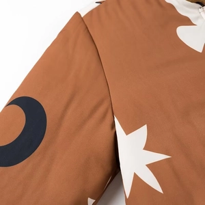 Detailaufnahme der braunen Bomberjacke mit schwarzen Mond- und weißen Sternenprints