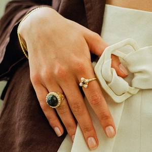 Macro view of vintage cocktail ring with dark gemstone, pearls and golden jewelry details