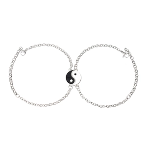 Close-up of yin yang charm pendants on stainless steel cable chains for couples