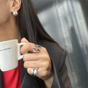 Stylized silver minimalist stackable rings and earrings shown with a lifestyle backdrop