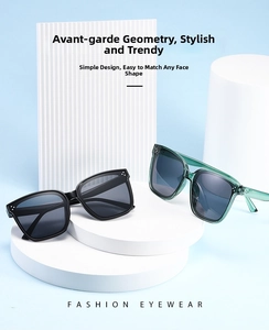 Detail view of black and transparent green oversized square sunglasses on display stands