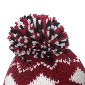 Detail view of the geometric knit pattern and soft tri-color pom-pom on the winter hat