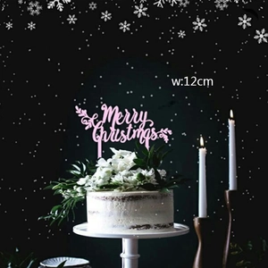 Close-up of pink Merry Christmas acrylic cake topper measuring 12cm wide on white floral cake