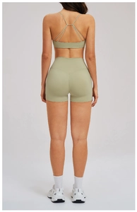 Back view of yoga set featuring cross-strap sports bra and high waist green shorts