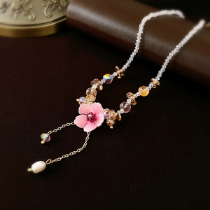 Detail of pink flower pendant necklace with crystal beads and elegant pearl tassel