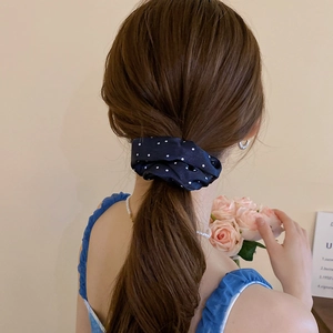 Polka dot oversized scrunchie in navy blue silk shown on a low ponytail with elegant vibe