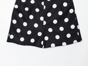 Detail view of polka dot shorts showing smooth woven fabric texture and clean stitching