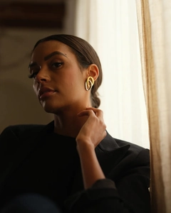 Close-up of dual-tone interlocking oval earrings in gold and silver finish on a model