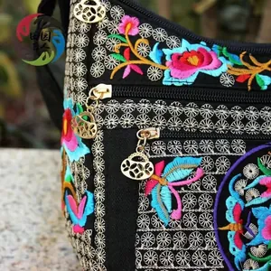 Detailed macro view of ethnic embroidery patterns and premium gold zipper pulls on a black bag