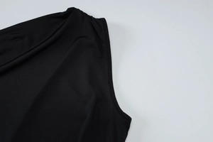 Gros plan sur le tissu élastique noir et les coutures de la robe à une épaule