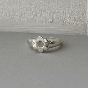 Elegant 925 sterling silver flower ring with adjustable open band on grey background