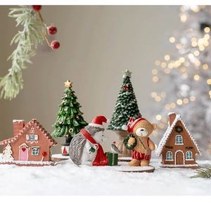 Miniature Christmas resin figurines including a gingerbread house and bear on a snow base