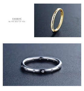 Close-up of gold and silver rings with pave set small diamonds on dark textured surface