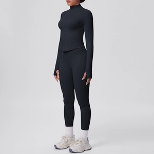 Vista laterale del set da yoga nero con giacca con collo alto e leggings a vita alta