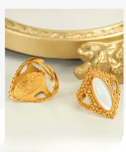 Detail of adjustable gold ring featuring a white oval opal stone and intricate beadwork