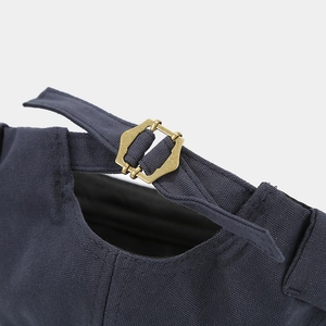 Detail of navy canvas docker hat with vintage brass buckle and adjustable strap