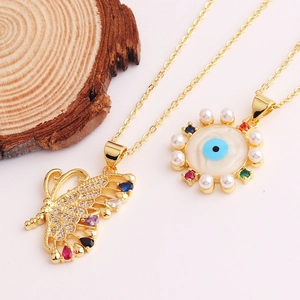 Detail of gold butterfly and evil eye necklaces with colorful zircons and pearls