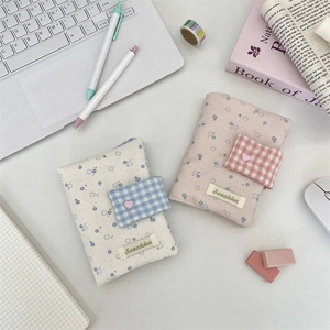 Floral fabric notebook cover with heart buckle detail and desk stationery items