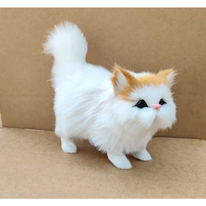 Close-up of realistic white plush cat with orange ears and striking blue eyes