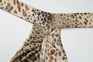 Detailed macro view of leopard print fabric with central woven braiding on backless dress