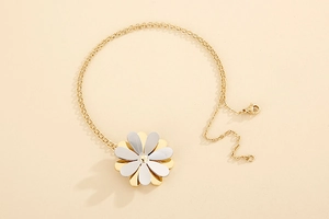 Detailed close-up of a daisy pendant with gold and silver petals on a fine chain